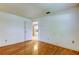 Spacious bedroom with hardwood floors, neutral walls, and view to the kitchen at 3310 Tanglewood Trl, Palm Harbor, FL 34685