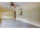 Empty, tiled bonus room featuring a pass-through window to the kitchen and natural light at 3310 Tanglewood Trl, Palm Harbor, FL 34685