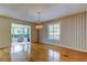 Traditional dining room with hardwood floors, elegant chandelier, and large window with shutter offering natural light at 3310 Tanglewood Trl, Palm Harbor, FL 34685