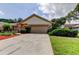 Exterior view of a one-story home with a two-car garage and a lush green lawn at 3310 Tanglewood Trl, Palm Harbor, FL 34685
