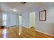 Bright foyer featuring hardwood floors, a white front door, and access to various rooms in the home at 3310 Tanglewood Trl, Palm Harbor, FL 34685