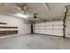 Spacious garage featuring an automatic door, shelving, and ample room for parking and storage at 3310 Tanglewood Trl, Palm Harbor, FL 34685