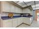 Kitchen features custom white cabinets, tile floors, and light countertops at 3310 Tanglewood Trl, Palm Harbor, FL 34685