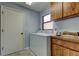 Functional laundry room featuring a washing machine, a sink, and ample cabinet space at 3310 Tanglewood Trl, Palm Harbor, FL 34685