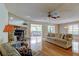 Inviting living room with hardwood floors, fireplace, access to a sunroom, and classic furnishings at 3310 Tanglewood Trl, Palm Harbor, FL 34685