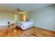 Bright main bedroom featuring polished wood floors, a ceiling fan, and access to the en-suite bathroom at 3310 Tanglewood Trl, Palm Harbor, FL 34685