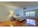 Bright main bedroom with polished wood floors, ceiling fan and natural light from a large window at 3310 Tanglewood Trl, Palm Harbor, FL 34685