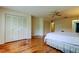Bright main bedroom featuring polished wood floors, a ceiling fan, and large closets at 3310 Tanglewood Trl, Palm Harbor, FL 34685