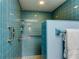 Shower featuring blue square tiles, metal fixtures, and a towel bar at 3310 Tanglewood Trl, Palm Harbor, FL 34685