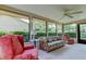 Bright sunroom filled with natural light, a patterned sofa, and views of the landscaped yard at 3310 Tanglewood Trl, Palm Harbor, FL 34685