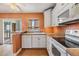 Bright kitchen featuring white cabinets, modern appliances, and views into the lanai at 4801 Airport Rd # 214, Zephyrhills, FL 33542