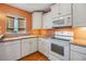 Bright kitchen featuring white cabinets, modern appliances, and warm countertops at 4801 Airport Rd # 214, Zephyrhills, FL 33542