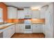 Bright kitchen with white cabinets, modern appliances, and warm countertops at 4801 Airport Rd # 214, Zephyrhills, FL 33542