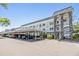 Exterior view of attractive condos with covered parking, stone accents, and beautiful landscaping at 4801 Airport Rd # 214, Zephyrhills, FL 33542