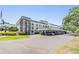 Front exterior of condos featuring manicured lawn, handicap parking, covered parking, and stone accents at 4801 Airport Rd # 214, Zephyrhills, FL 33542