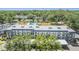 Inviting aerial view of condos with a community pool surrounded by green spaces and lush trees at 4801 Airport Rd # 214, Zephyrhills, FL 33542