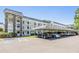 Exterior view of condos with covered parking, stone accents, and accessible parking at 4801 Airport Rd # 214, Zephyrhills, FL 33542