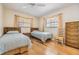 Bedroom includes hardwood floors, two twin beds, and natural light from two windows at 4801 Airport Rd # 214, Zephyrhills, FL 33542