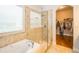 Bathroom featuring tiled shower and a soaking tub with tile surround plus walk in closet at 4810 Diamonds Palm Loop, Wesley Chapel, FL 33543