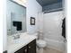 Stylish bathroom featuring a modern vanity, a soaking tub with a shower, and contemporary fixtures at 4810 Diamonds Palm Loop, Wesley Chapel, FL 33543