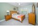 Light-filled bedroom with a wooden bed frame, neutral linens, and bedside tables with lamps at 4810 Diamonds Palm Loop, Wesley Chapel, FL 33543