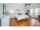 Well-lit bedroom with hardwood floors, white furniture, and a large window with natural light at 4810 Diamonds Palm Loop, Wesley Chapel, FL 33543