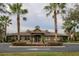 Community clubhouse featuring meticulously maintained landscaping and symmetrical palm trees at 4810 Diamonds Palm Loop, Wesley Chapel, FL 33543