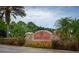 Community entrance sign with stone accents, landscaping, and vibrant flowers at 4810 Diamonds Palm Loop, Wesley Chapel, FL 33543