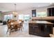 Open kitchen and dining area with island seating and a view of the outdoor patio and lake at 4810 Diamonds Palm Loop, Wesley Chapel, FL 33543