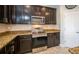 Stylish kitchen with granite countertops, stainless steel appliances, and dark wood cabinetry at 4810 Diamonds Palm Loop, Wesley Chapel, FL 33543