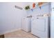 Bright laundry room with a washer and dryer with tiled floors and a shelf at 4810 Diamonds Palm Loop, Wesley Chapel, FL 33543