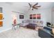 Inviting living room with tile floors, a comfortable sofa, large fan and bright natural lighting at 4810 Diamonds Palm Loop, Wesley Chapel, FL 33543