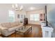Light-filled living room features hardwood floors, a plush sofa, and large windows at 4810 Diamonds Palm Loop, Wesley Chapel, FL 33543