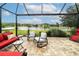 Screened-in patio with outdoor furniture overlooking a beautiful lake at 4810 Diamonds Palm Loop, Wesley Chapel, FL 33543