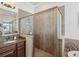 Modern bathroom featuring tiled walk-in shower with a glass door and double vanity at 525 Manns Harbor Dr, Apollo Beach, FL 33572