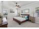 Bright bedroom features neutral colors, a ceiling fan, and stylish wooden furniture at 525 Manns Harbor Dr, Apollo Beach, FL 33572
