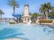 Resort-style community pool featuring a lighthouse, water slides, and lush tropical landscaping for a vacation-like experience at 525 Manns Harbor Dr, Apollo Beach, FL 33572