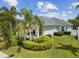 Beautiful home with a well-maintained lawn, lush tropical landscaping, and a charming front porch at 525 Manns Harbor Dr, Apollo Beach, FL 33572