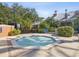 Community hot tub surrounded by brick pavers, lush landscaping, and black iron fencing for privacy at 525 Manns Harbor Dr, Apollo Beach, FL 33572
