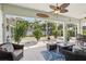 Enclosed patio with ample seating, tropical plants, and a ceiling fan at 525 Manns Harbor Dr, Apollo Beach, FL 33572