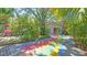 Fun and quirky driveway with a rainbow brick design leading to a charming garage surrounded by lush landscaping at 6014 Luana S Ln, Gulfport, FL 33707