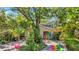 Charming home exterior with mature trees, a colorful driveway, and unique garage door art at 6014 Luana S Ln, Gulfport, FL 33707