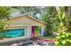 This garage features artwork on the garage doors and a painted driveway, adding unique and artistic appeal at 6014 Luana S Ln, Gulfport, FL 33707