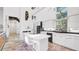 Bright kitchen with an island, modern white cabinets, stainless appliances, and unique flooring at 6014 Luana S Ln, Gulfport, FL 33707