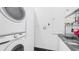 Well-lit laundry room featuring a stacked washer and dryer with sink at 6014 Luana S Ln, Gulfport, FL 33707