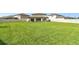 Lush backyard with a spacious lawn, enclosed by a white fence at 6700 Devlin Ln, Wesley Chapel, FL 33545