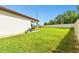 Spacious backyard with lush green grass and a covered patio area at 6700 Devlin Ln, Wesley Chapel, FL 33545