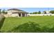 Large backyard showing a home with a covered patio and a well-manicured lawn at 6700 Devlin Ln, Wesley Chapel, FL 33545