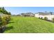 Expansive backyard with a lush green lawn, privacy fence, and well-manicured landscaping at 6700 Devlin Ln, Wesley Chapel, FL 33545