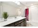 Bright bathroom featuring a quartz countertop, dark cabinetry, large mirror and a shower/tub combo at 6700 Devlin Ln, Wesley Chapel, FL 33545